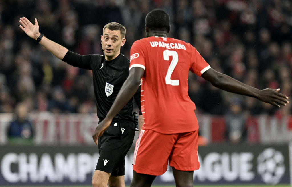 Bayern Munich's French defender Dayot Upamecano (R) discusses with French referee Clement Turpin during the UEFA Champions League quarter-final, se...