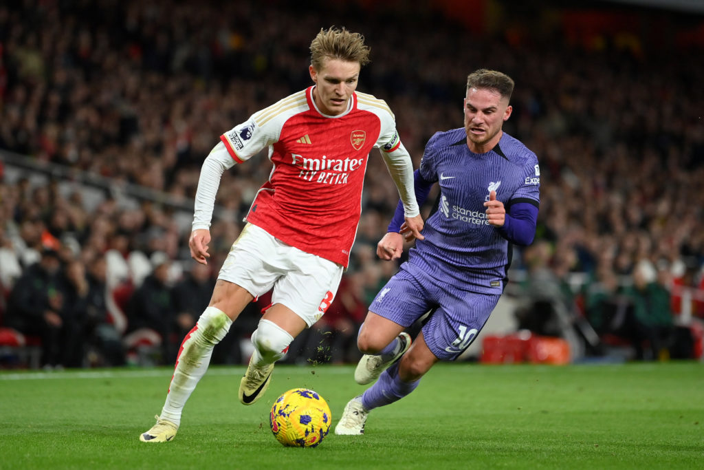 Alexis Mac Allister chasing Martin Odegaard as he runs with the ball during a game between Arsenal and Liverpool