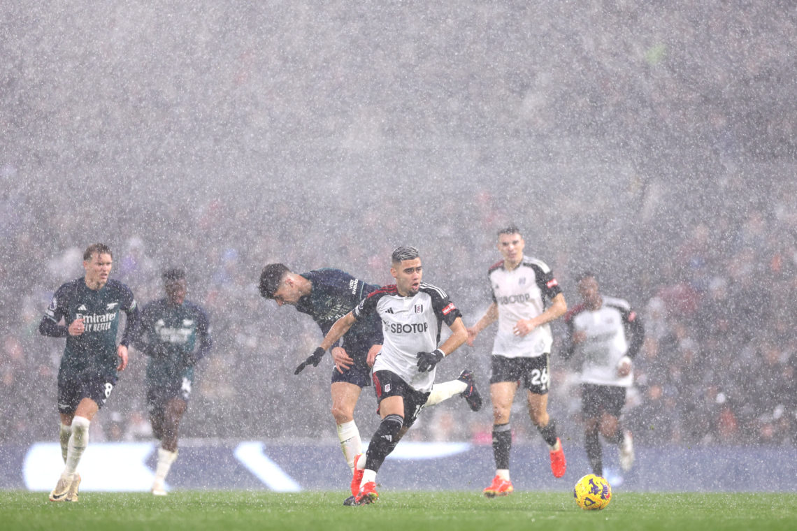 Andreas Pereira of Fulham runs with the ball in a rain storm during the Premier League match between Fulham FC and Arsenal FC at Craven Cottage on ...