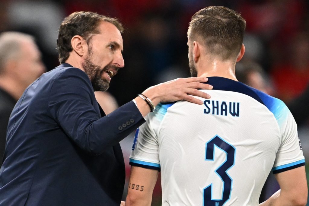 England's coach Gareth Southgate talks to England's defender #03 Luke Shaw during the Qatar 2022 World Cup Group B football match between Wales and...