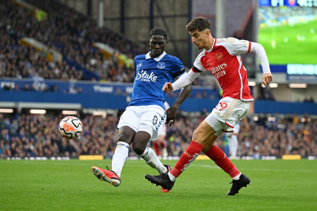 Kai Havertz of Arsenal crosses the ball whilst under pressure from Amadou Onana of Everton during the Premier League match between Everton FC and A...