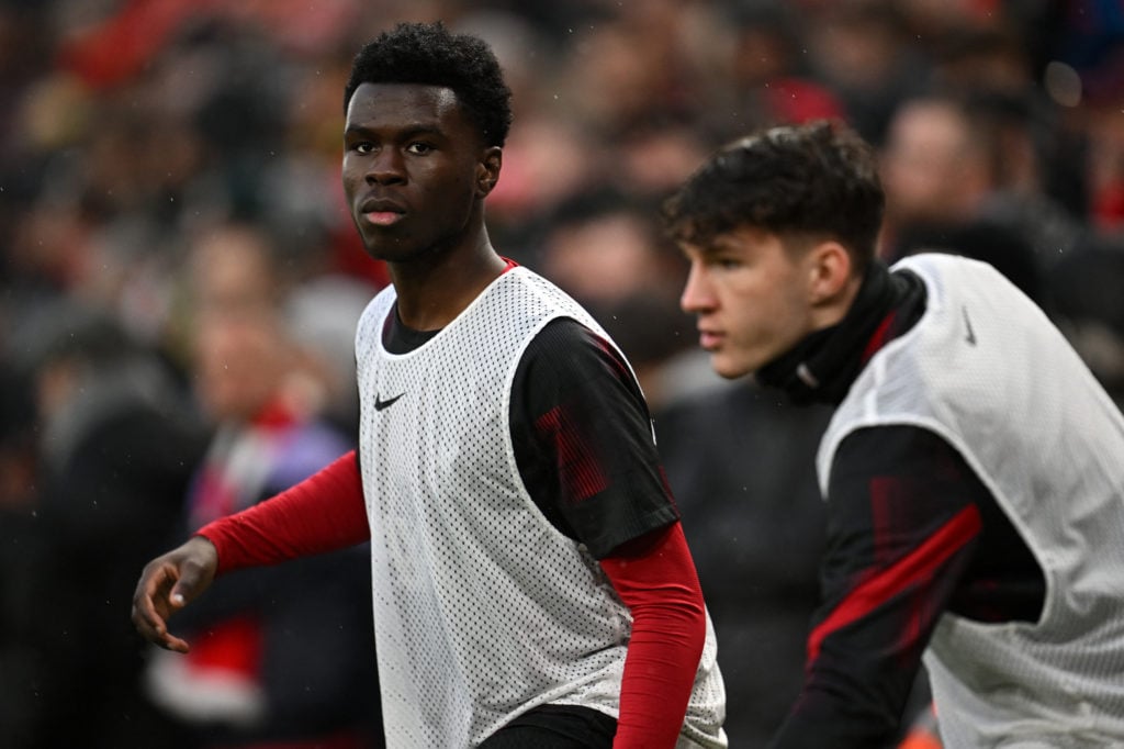 Liverpool's English defender #65 Amara Nallo (L) warms up on the sidelines during the English Premier League football match between Liverpool and M...