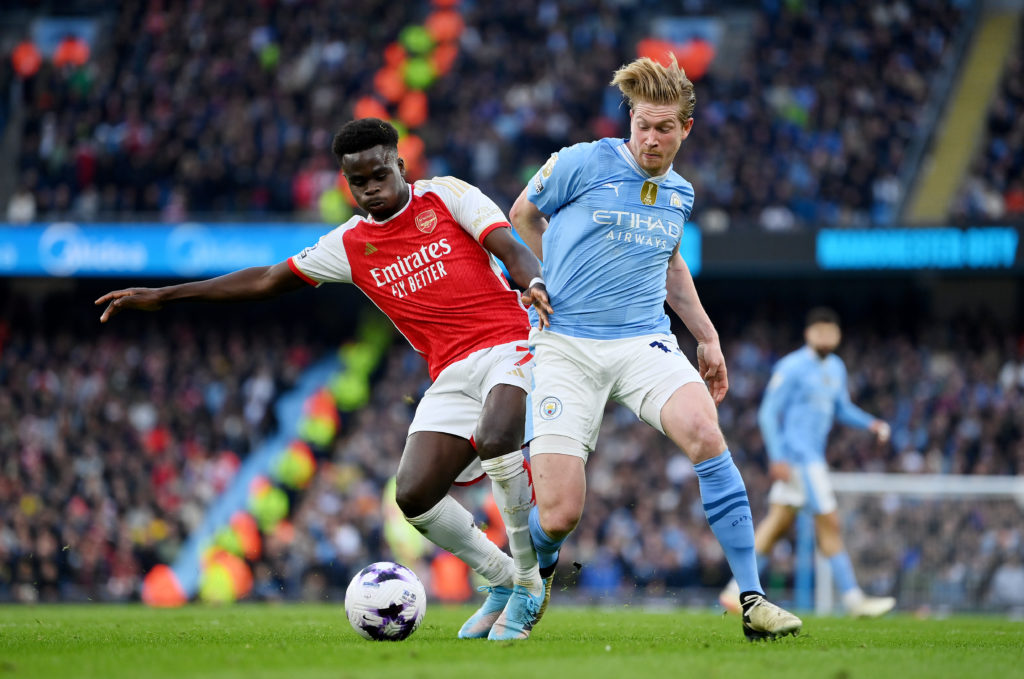 Bukayo Saka of Arsenal battles for possession with Kevin De Bruyne of Manchester City during the Premier League match between Manchester City and A...