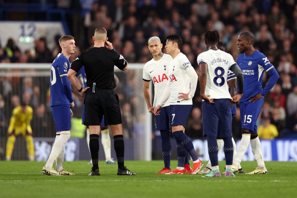 Referee Robert Jones speaks with Cole Palmer of Chelsea and Richarlison, Son Heung-Min and Yves Bissouma of Tottenham Hotspur as they await the res...