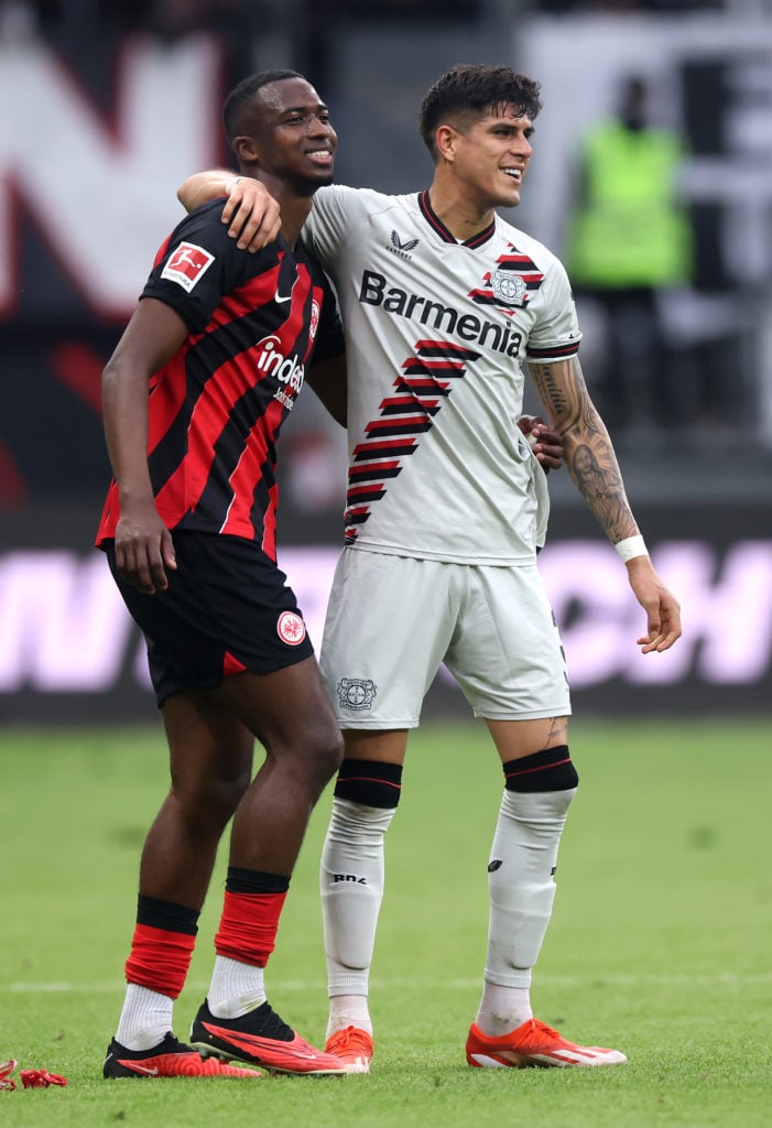 William Pacho of Eintracht Frankfurt is consoled by Piero Hincapie of Bayer Leverkusen after the Bundesliga match between Eintracht Frankfurt and B...