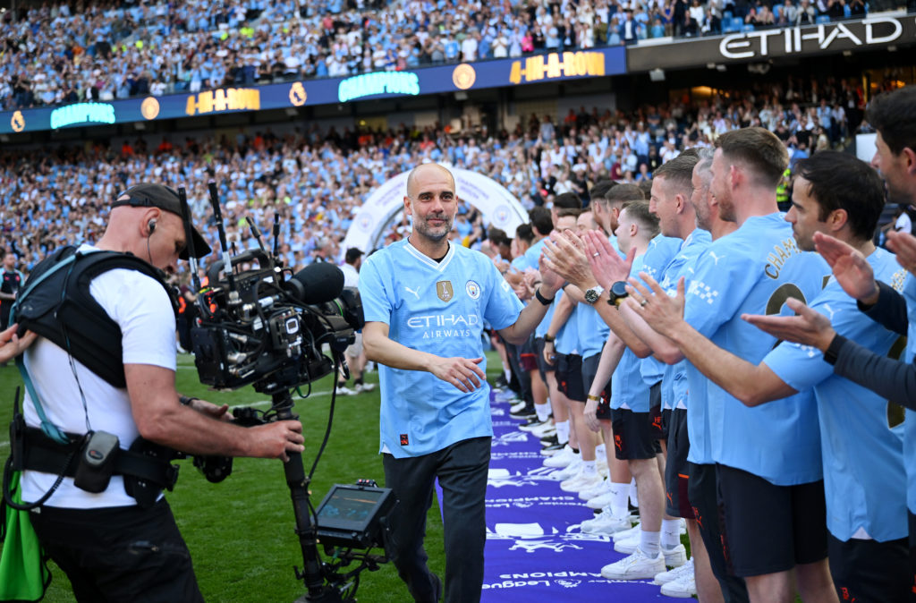 Pep Guardiola, Manager of Manchester City, congratulates staff after the team's victory as Premier League champions before the trophy ceremony duri...