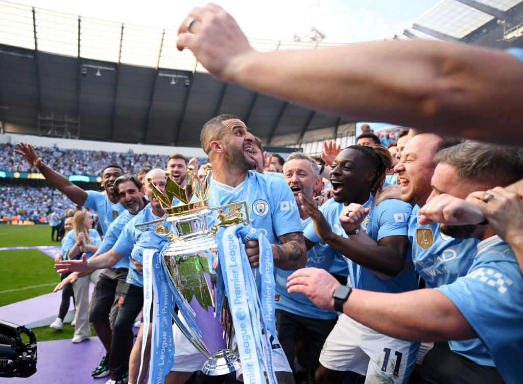 Kyle Walker of Manchester City prepares to lift The Premier League Trophy on the stage as players of Manchester City react after the Premier League...