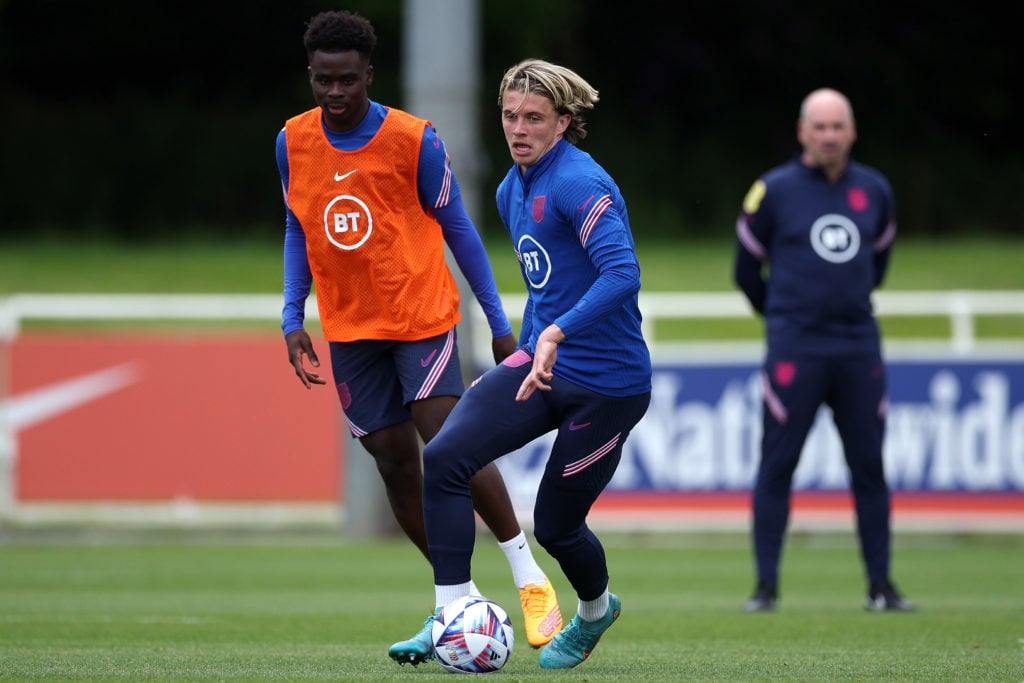 Conor Gallagher of England holds off pressure from team mate Bukayo Saka during a training session at St Georges Park on May 30, 2022 in Burton-upo...