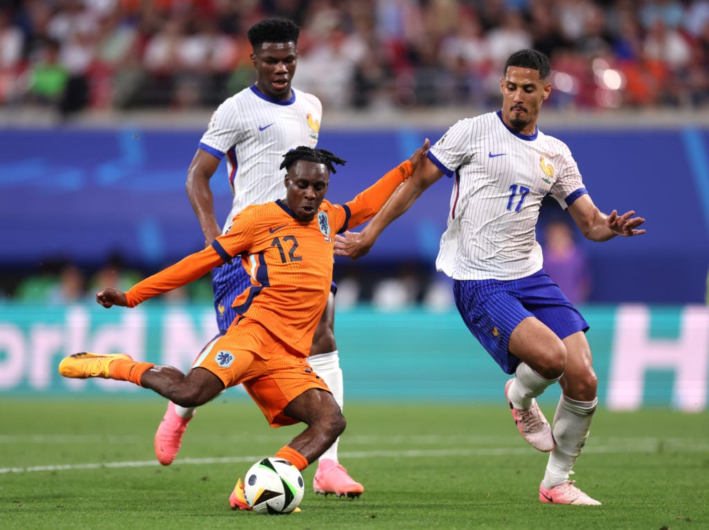 Jeremie Frimpong of the Netherlands shoots whilst under pressure from William Saliba of France during the UEFA EURO 2024 group stage match between ...