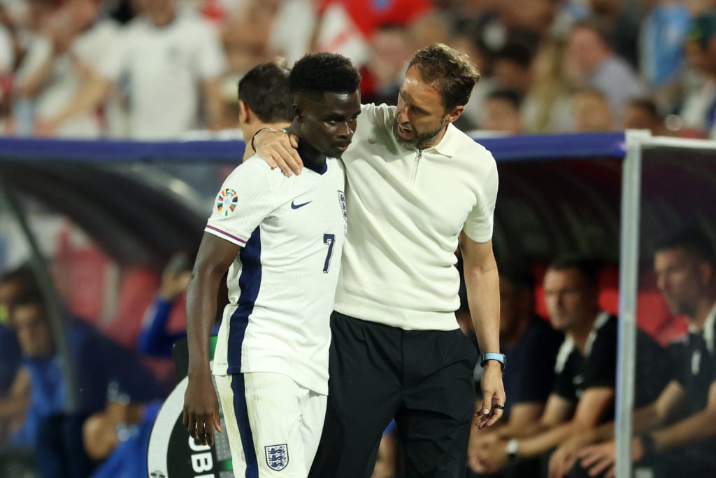 Bukayo Saka of England is embraced by Gareth Southgate, Head Coach of England, after being replaced by substitute Cole Palmer (not pictured) during...