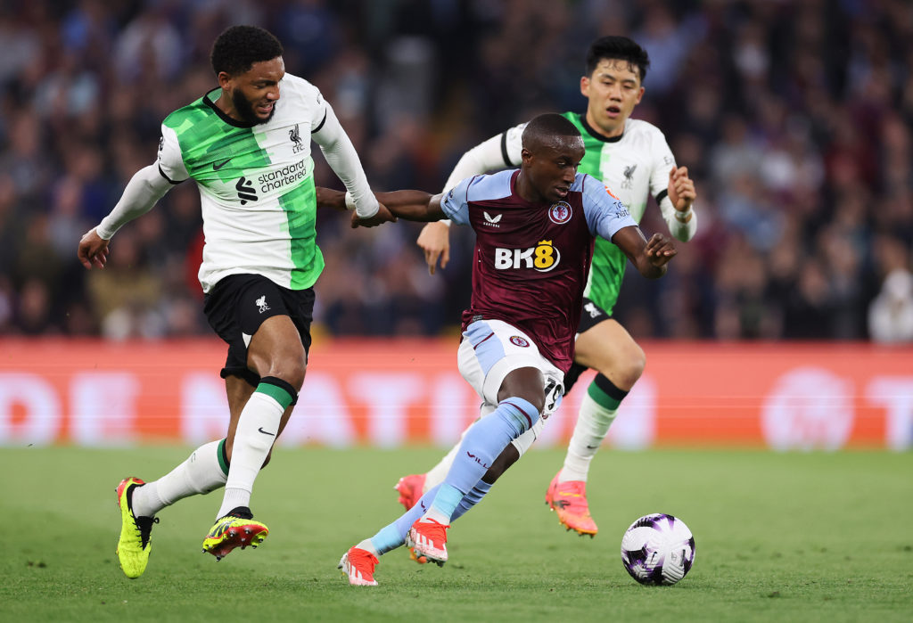 Moussa Diaby of Aston Villa runs with the ball whilst under pressure from Joe Gomez of Liverpool during the Premier League match between Aston Vill...