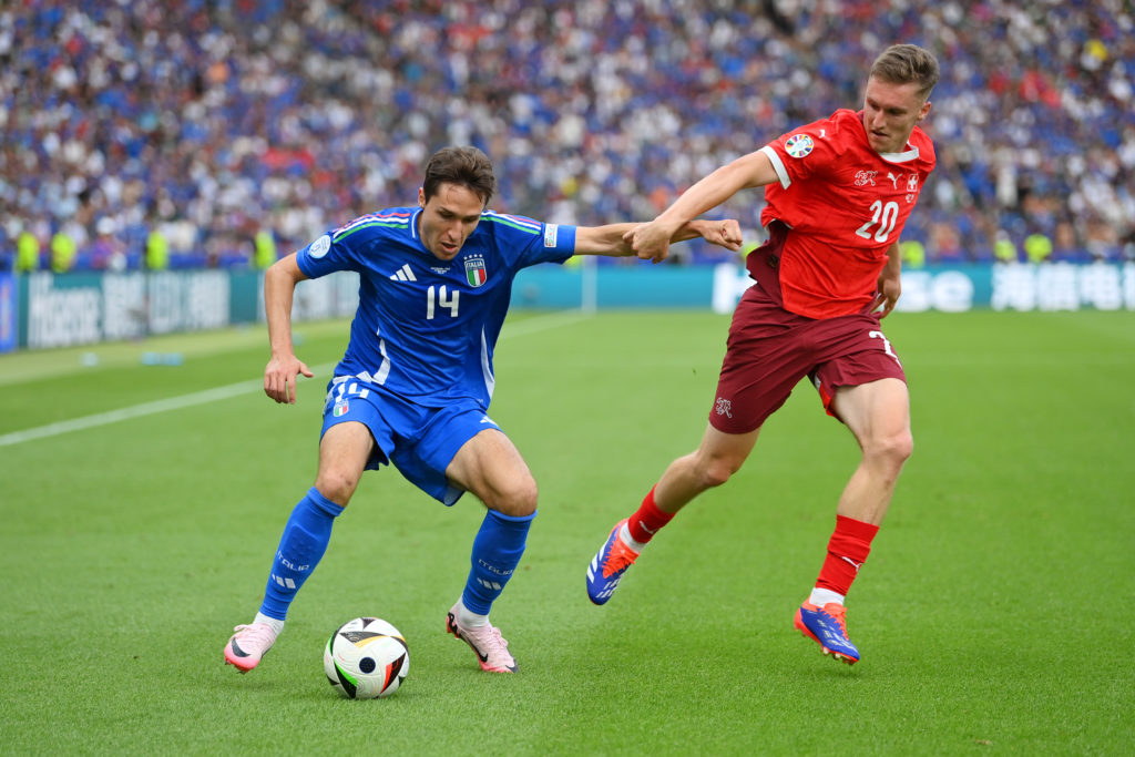 Federico Chiesa of Italy controls the ball whilst under pressure from Michel Aebischer of Switzerland during the UEFA EURO 2024 round of 16 match b...