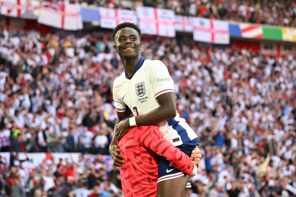 Bukayo Saka of England celebrates scoring his team's first goal with teammate Aaron Ramsdale during the UEFA EURO 2024 quarter-final match between ...