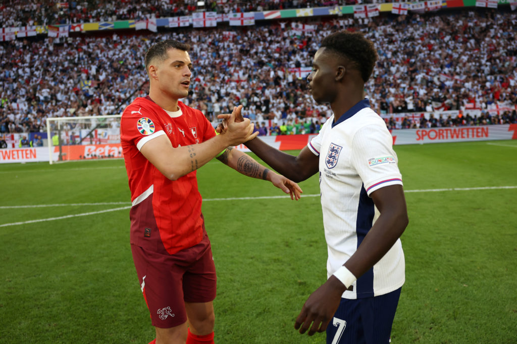 Granit Xhaka of Switzerland interacts with Bukayo Saka of England after the penalty shoot out during the UEFA EURO 2024 quarter-final match between...