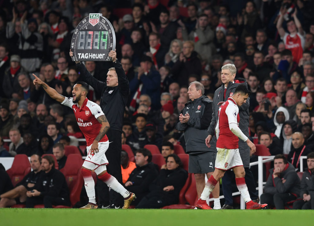 Theo Walcott comes on as a sub for Alexis Sanchez of Arsenal as Arsene Wenger the Arsenal Manager look on during the Premier League match between A...