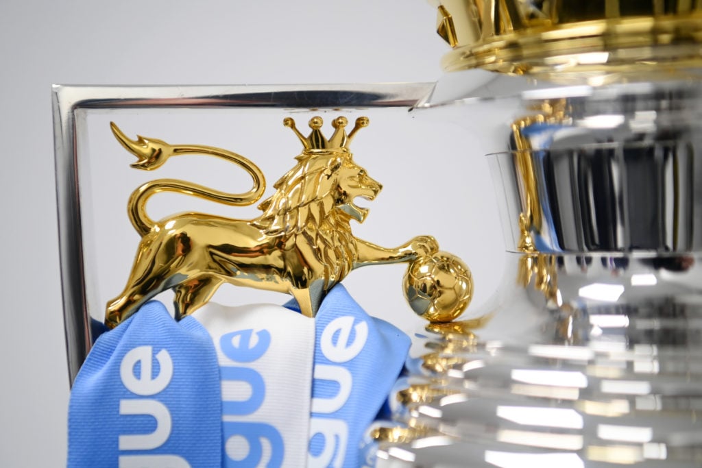 Ribbons in the colours of Manchester City are placed onto the Premier League trophy after their side finished the 2021/2022 season as champions aft...