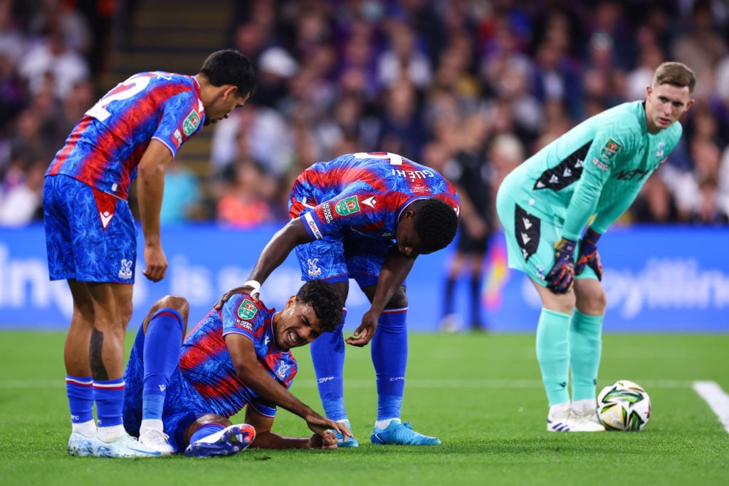 Marc Guehi of Crystal Palace comforts Chadi Riad of Crystal Palace as he goes down injured during the Carabao Cup Second Round match between Crysta...