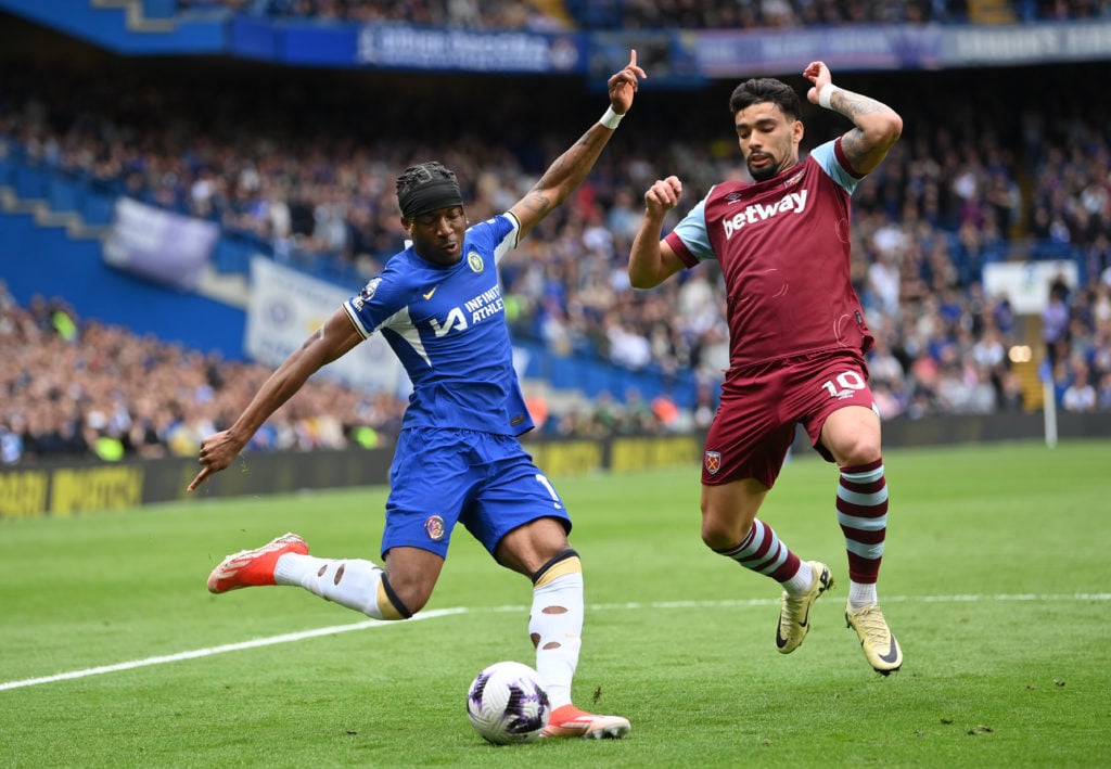 Noni Madueke of Chelsea crosses the ball whilst under pressure from Lucas Paqueta of West Ham United during the Premier League match between Chelse...