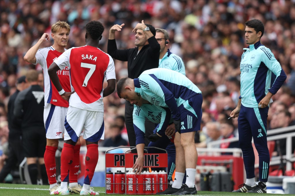 Martin Odegaard of Arsenal, Bukayo Saka of Arsenal and Mikel Arteta, Manager of Arsenal on the side line during the Premier League match between Ar...