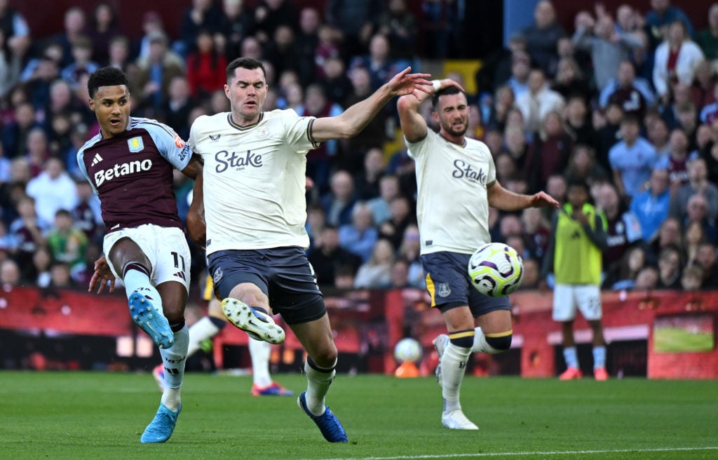 Ollie Watkins of Aston Villa scores his team's second goal under pressure from Michael Keane of Everton during the Premier League match between Ast...