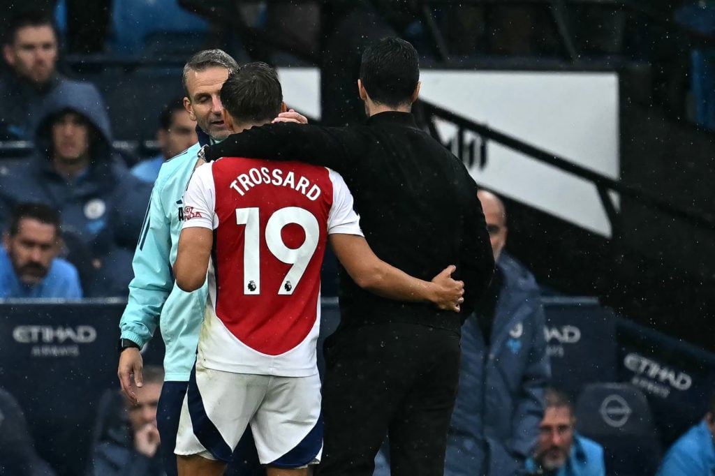 Arsenal's Spanish manager Mikel Arteta hugs Arsenal's Belgian midfielder #19 Leandro Trossard as he leaves the pitch after being given a straight r...