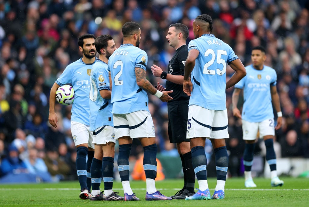 Bernardo Silva and Kyle Walker of Manchester City talk to Referee, Michael Oliver during the Premier League match between Manchester City FC and Ar...