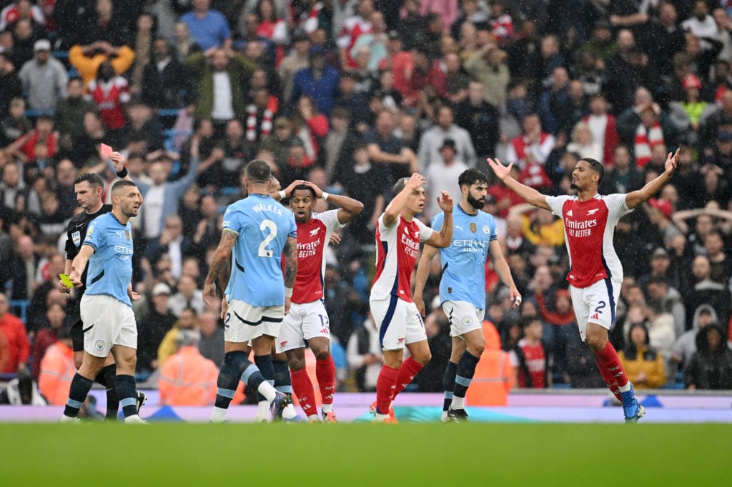 Players react as Referee, Michael Oliver shows a red card to Leandro Trossard of Arsenal during the Premier League match between Manchester City FC...