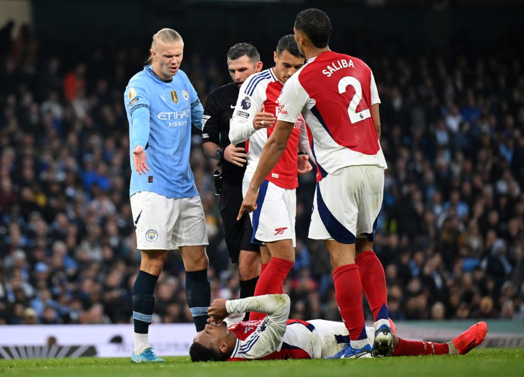 Erling Haaland of Manchester City protests to Referee, Michael Oliver as Gabriel of Arsenal reacts with an injury during the Premier League match b...