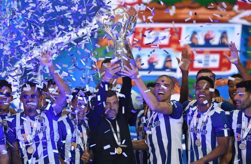 FC Porto's Portuguese defender Pepe (3-R) and FC Porto's Portuguese coach Sergio Conceicao (C) lift the Candido de Oliveira trophy with teammates f...