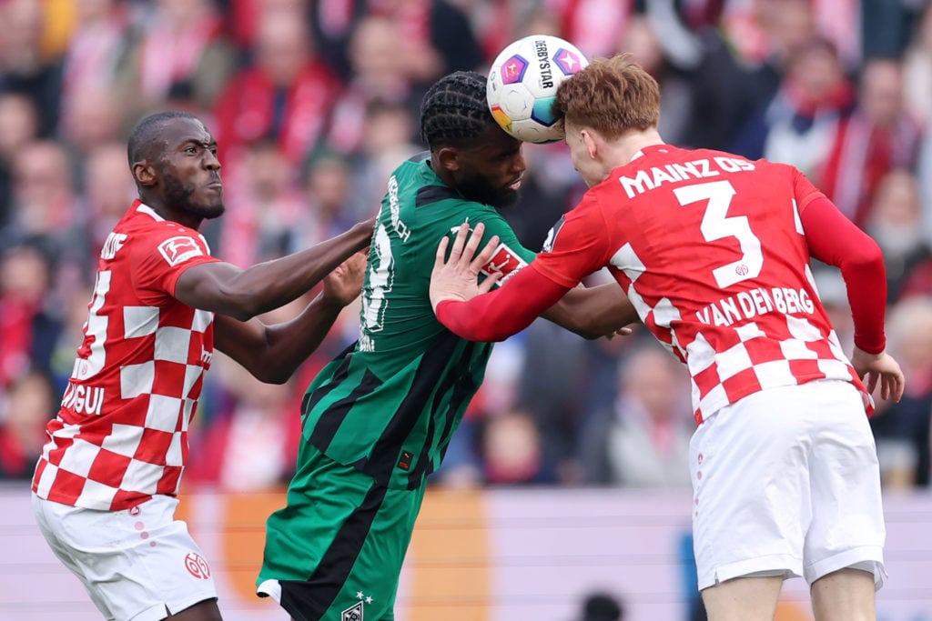 Jordan Siebatcheu of Borussia Moenchengladbach is challenged by Josuha Guilavogui and Sepp van den Berg of Mainz during the Bundesliga match betwee...