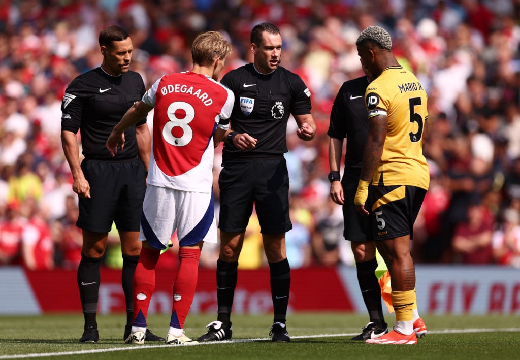 Referee, Jarred Gillett hosts the coin toss between Martin Odegaard of Arsenal and Mario Lemina of Wolverhampton Wanderers during the Premier Leagu...