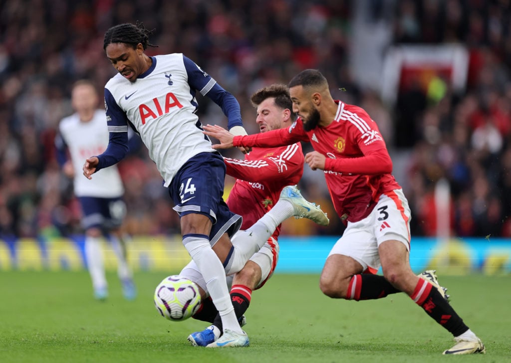 Djed Spence of Tottenham Hotspur is tackled by Mason Mount and Noussair Mazraoui of Manchester United during the Premier League match between Manch...