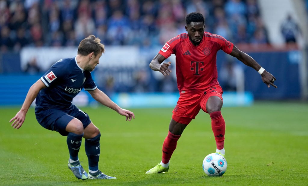 Alphonso Davies of Bayern Munich runs with the ball whilst under pressure from Felix Passlack of VfL Bochum during the Bundesliga match between VfL...