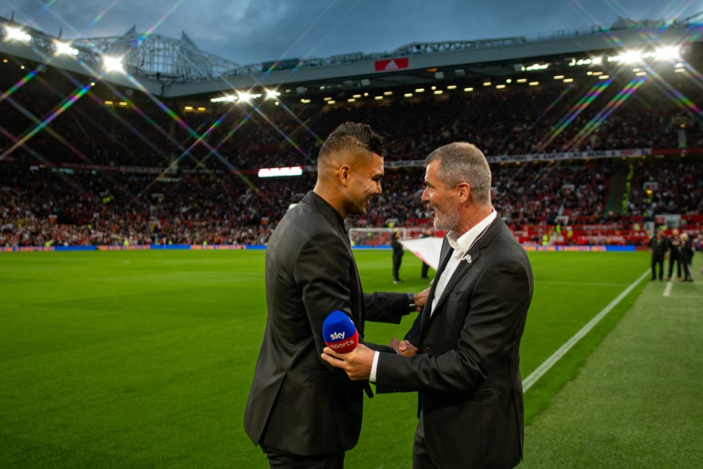 Casemiro of Manchester United greets Roy Keane ahead of the Premier League match between Manchester United and Liverpool FC at Old Trafford on Augu...