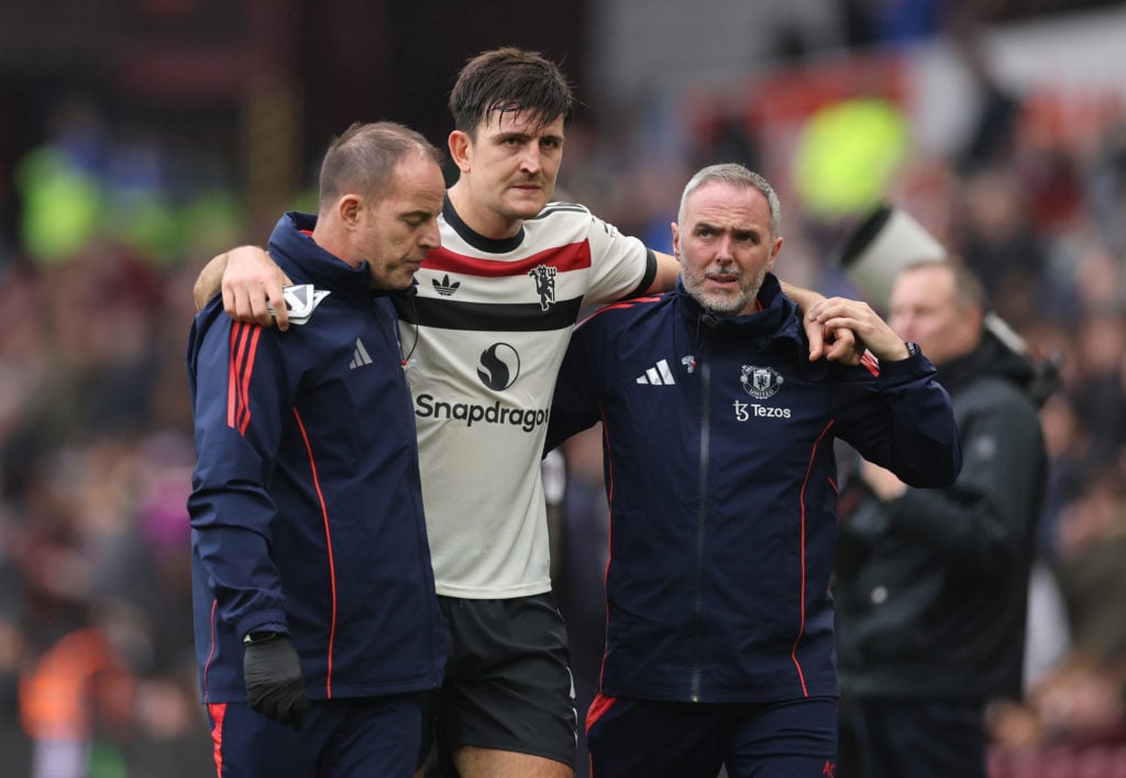 An injured Harry Maguire of Manchester United is helped off during the Premier League match between Aston Villa FC and Manchester United FC at Vill...