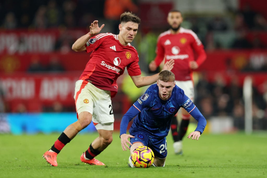 Cole Palmer of Chelsea goes down whilst battling for possession with Manuel Ugarte of Manchester United during the Premier League match between Man...