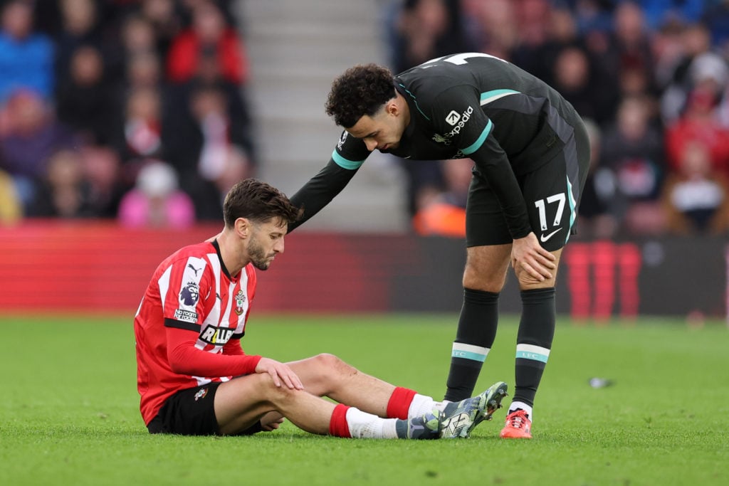 Adam Lallana of Southampton with Curtis Jones of Liverpool before being treated for an injury during the Premier League match between Southampton F...