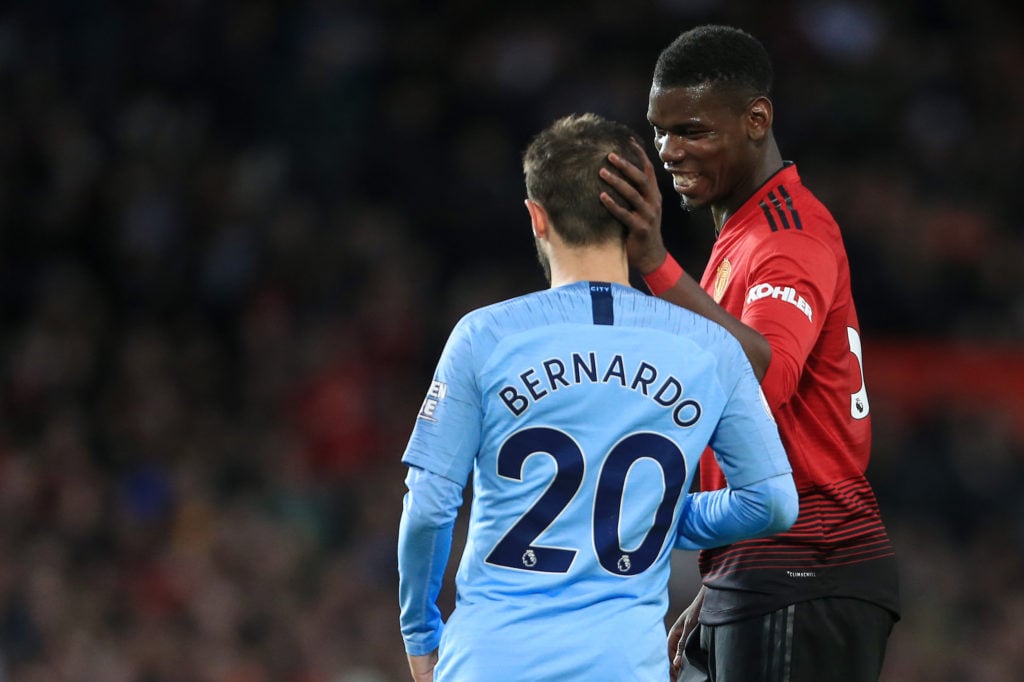 Paul Pogba of Man Utd talks to Bernardo Silva of Man City during the Premier League match between Manchester United and Manchester City at Old Traf...