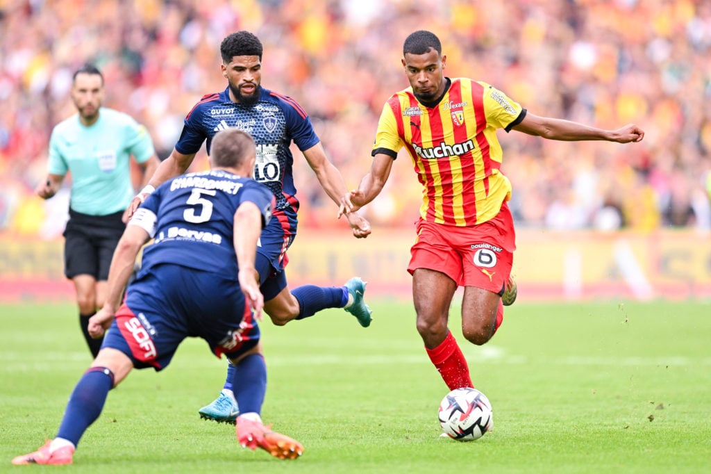 Andy Diouf of Lens runs with the ball under pressure from Mahdi Camara and Brendan Chardonnet of Stade Brestois 29 during the Ligue 1 match between...