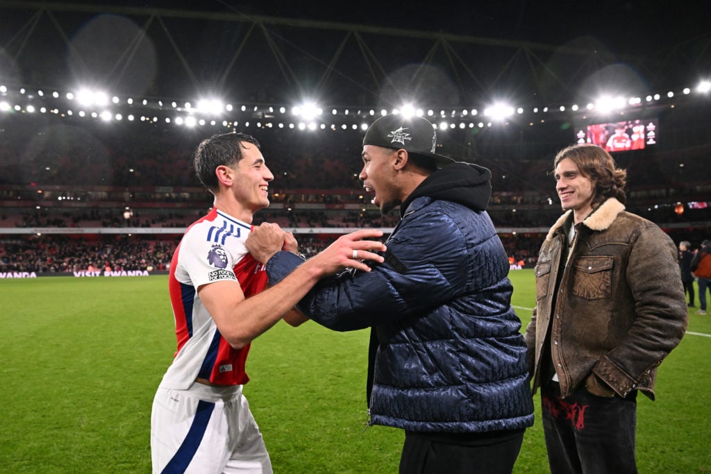 Jakub Kiwior of Arsenal celebrates with injured teammate Gabriel following the team's victory during the Premier League match between Arsenal FC an...