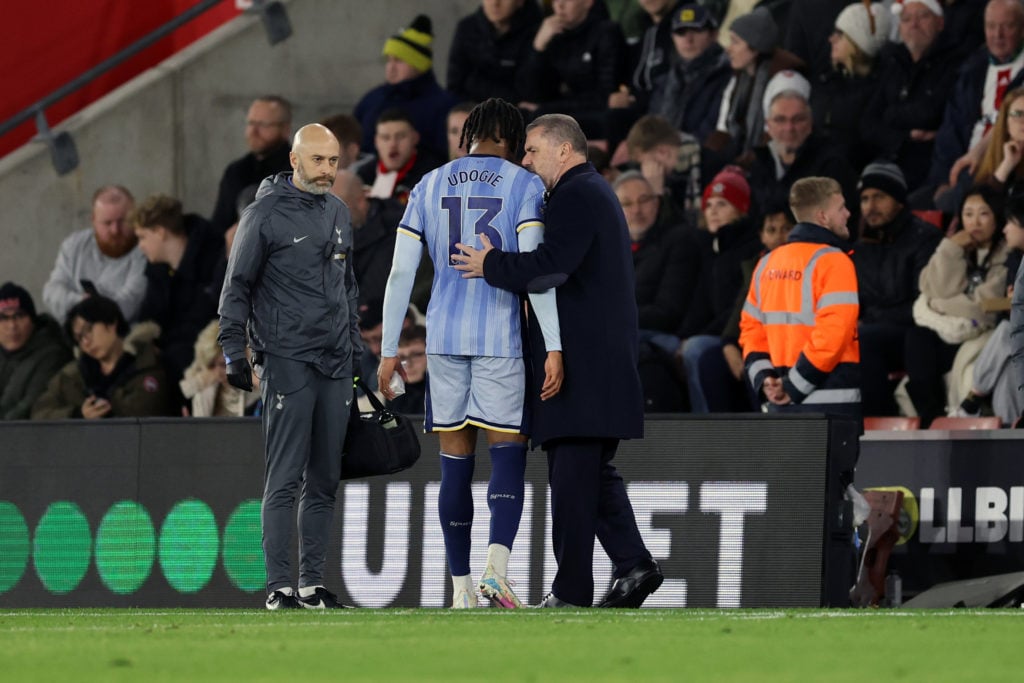 An injured Destiny Udogie of Tottenham Hotspur  is greeted by Ange Postecoglou manager / head coach of Tottenham Hotspur  during the Premier League...