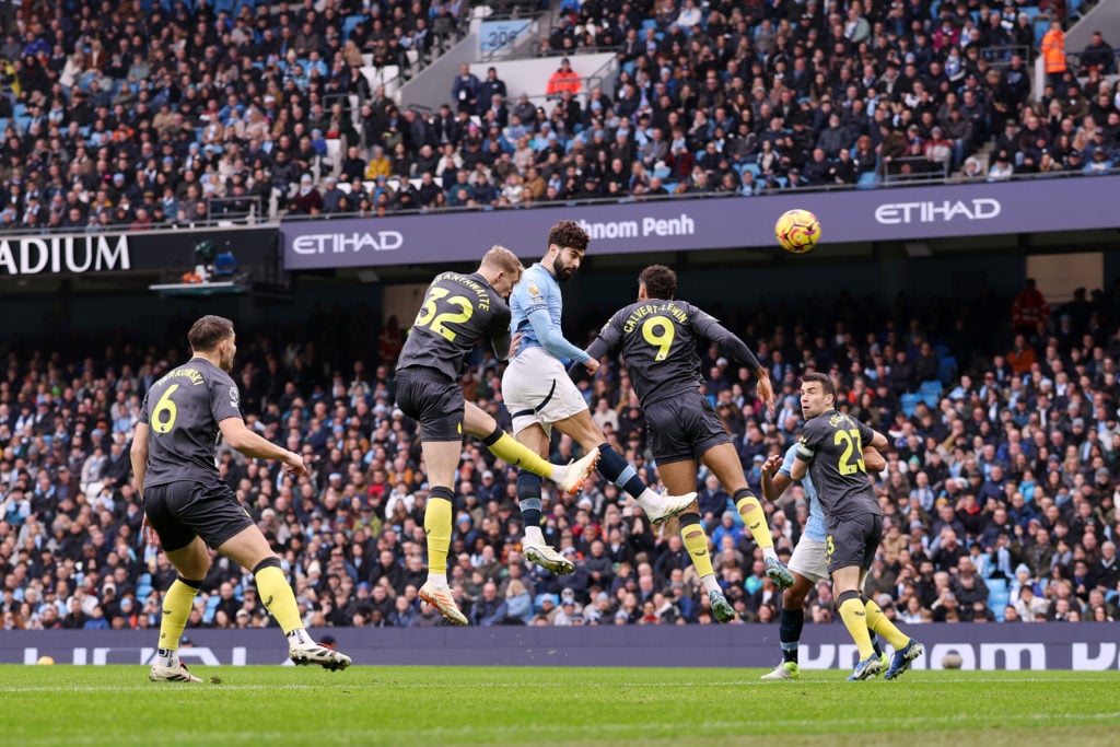 Josko Gvardiol of Manchester City heads the ball whilst under pressure from Dominic Calvert-Lewin and Jarrad Branthwaite of Everton during the Prem...