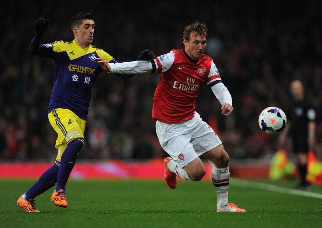 Kim Kallstrom of Arsenal holds off Angel Rangel of Swansea during the Barclays Premier League match between Arsenal and Swansea City at Emirates St...