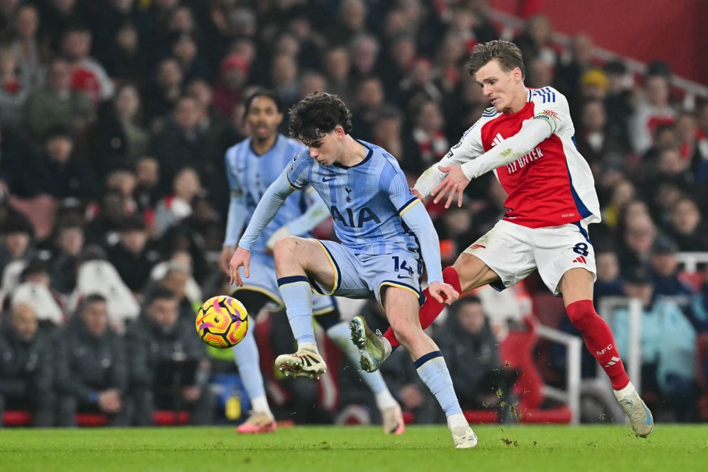 Tottenham Hotspur's English midfielder #14 Archie Gray (L) fights for the ball with Arsenal's Norwegian midfielder #08 Martin Odegaard during the E...