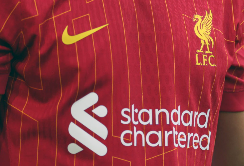 A closeup shot of the Liverpool home kit, with Standard Chartered and Nike branding visible as well as the badge