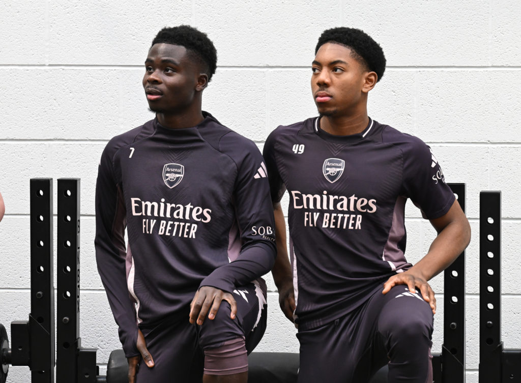 Bukayo Saka and Myles Lewis-Skelly looking on during an Arsenal training session in the gym