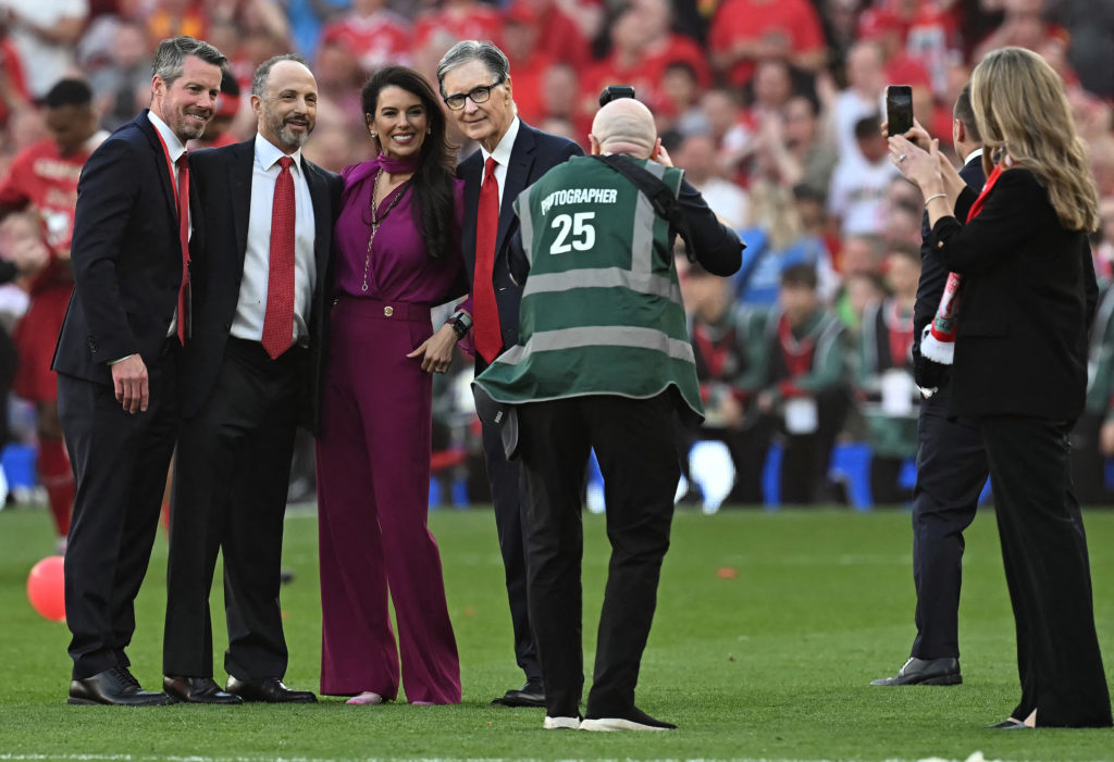 Liverpool and FSG owners John Henry, Linda Pizutti and, Mike Gordon pose for a picture alongside Richard Hughes on the pitch at Anfield