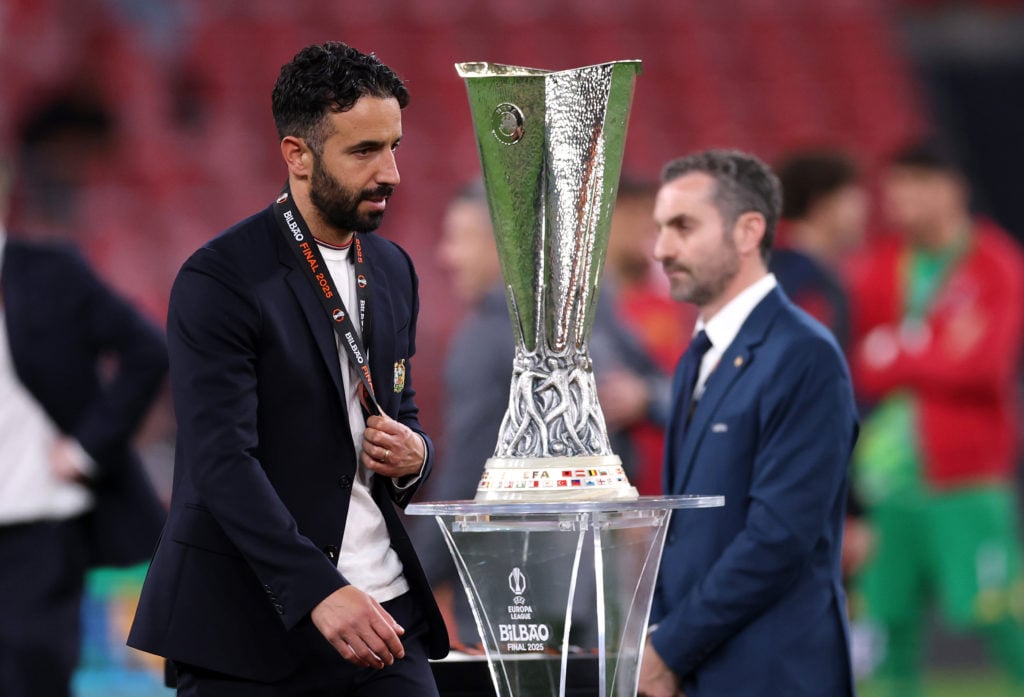 Manchester United manager Ruben Amorim looks dejected as he walks past the Europa League trophy.