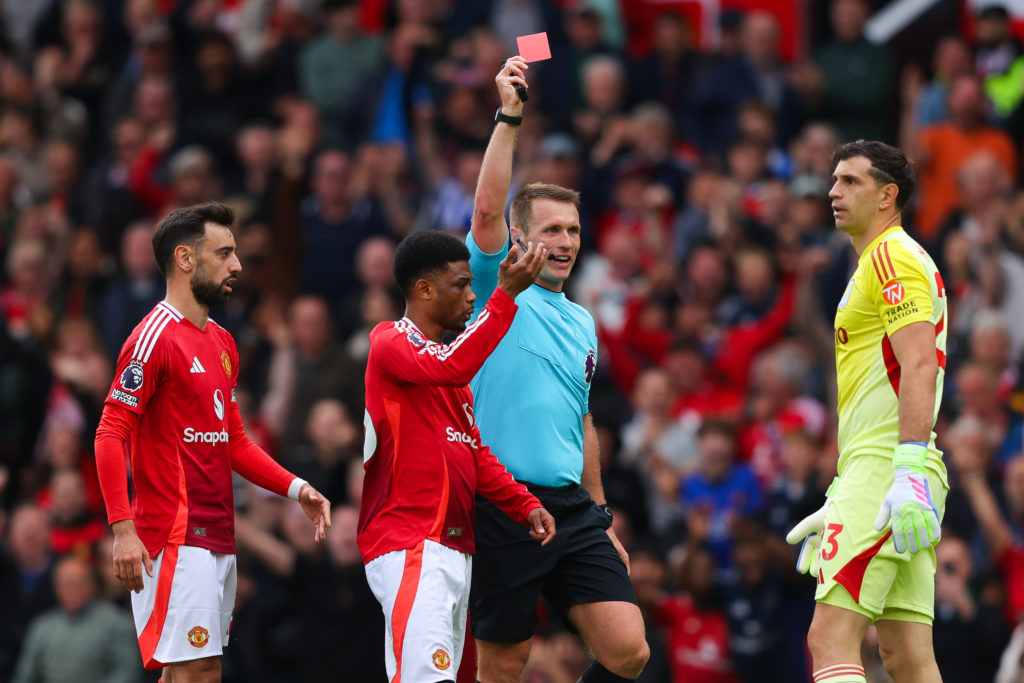 Referee Thomas Bramall shows a red card to Emiliano Martinez of Aston Villa during the Premier League match between Manchester United FC and Aston Villa