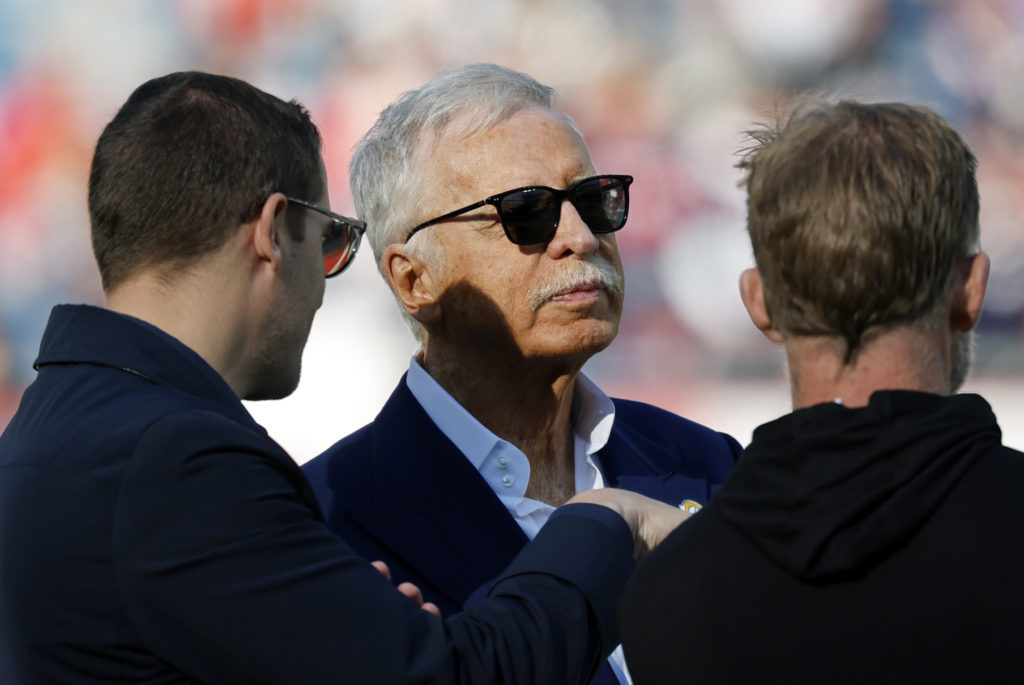 Arsenal owner Stan Kroenke wearing sunglasses and speaking with colleagues at a Los Angeles Rams NFL game